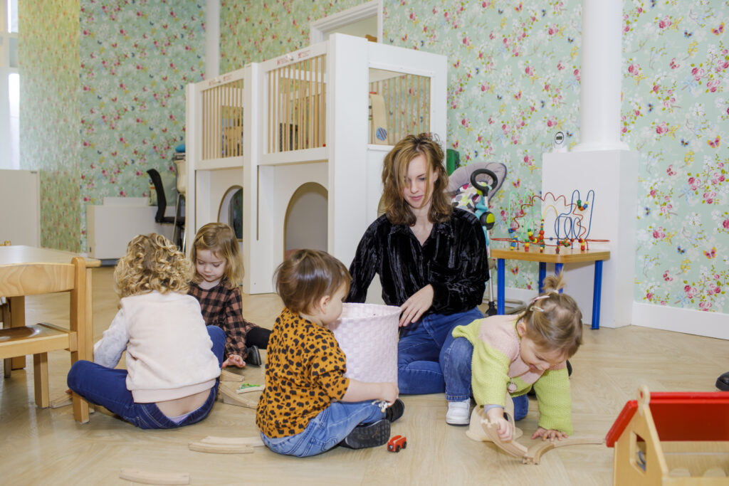 Pedagogisch medewerker speelt met kinderen in de groep bij Altijd Lente